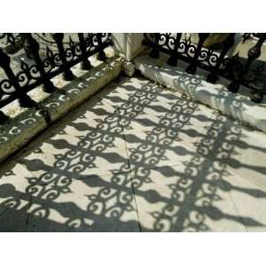 Close View of the Shadow Cast by the Ornate Detail of an Iron Fence 