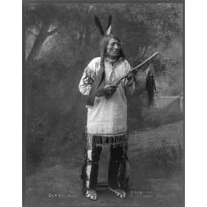   On a still hunt,c1900,holding scalp?,Indian,feathers